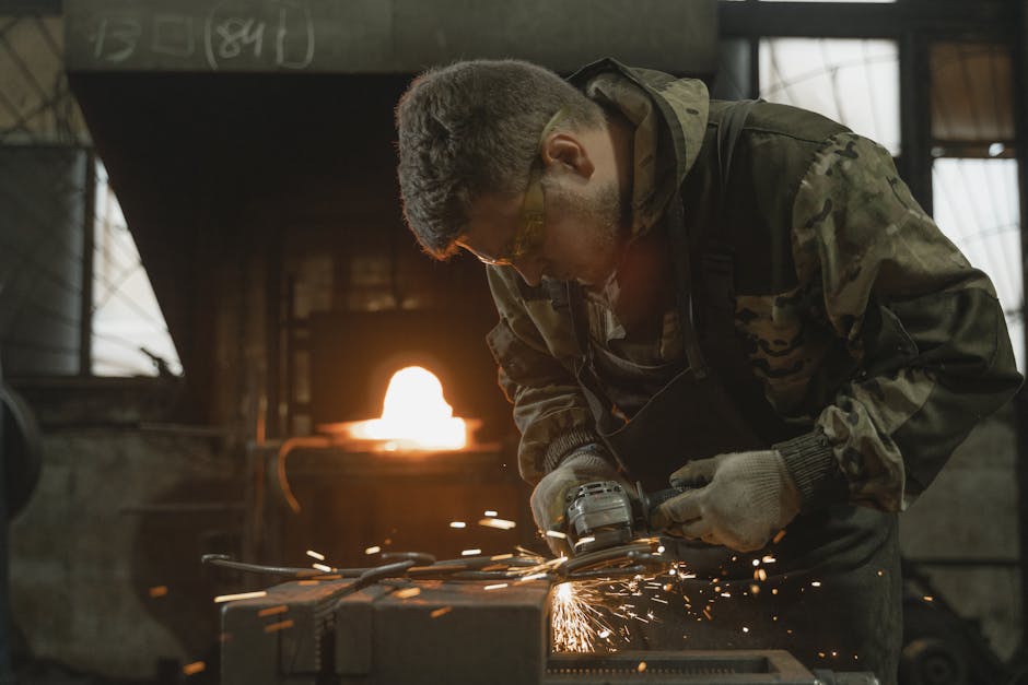 A blacksmith in protective gear operates a grinding machine in a forge, creating sparks.