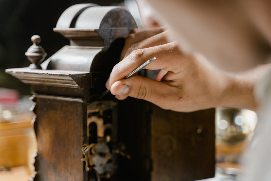 Close-up of hands skillfully restoring an antique wooden clock, highlighting craftsmanship.
