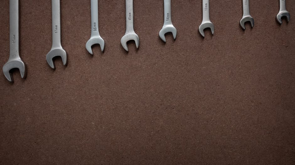 Top view of wrenches lined up on a textured brown surface, showcasing sizes.