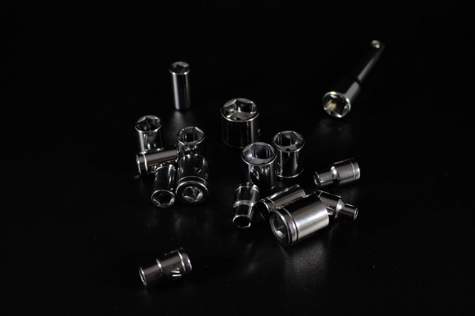Collection of stainless steel socket wrenches on a sleek black surface, emphasizing tools and hardware