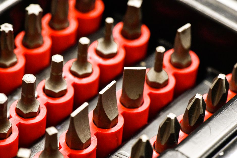 Detailed close-up of various metal screwdriver bits in red holders.