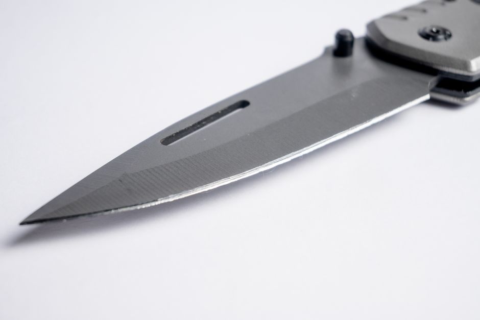 Sharp stainless steel folding knife blade close-up with a sleek design. Perfect for tactical and survival purposes.