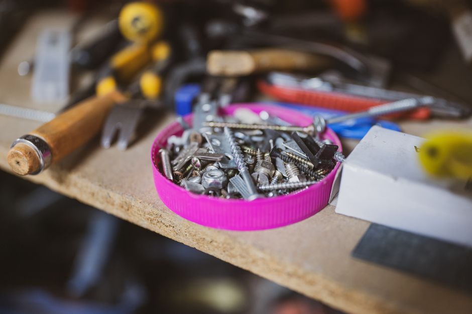 A detailed view of screws and various tools in a workshop, emphasizing craftsmanship and utility.