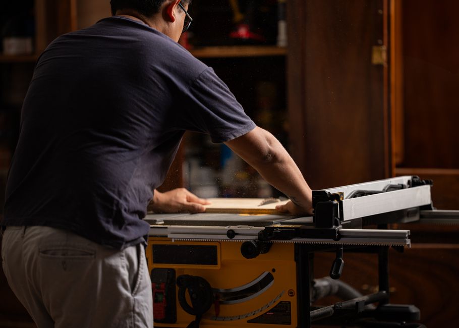 A person using a table saw, engaging in woodworking indoors in Costa Rica.