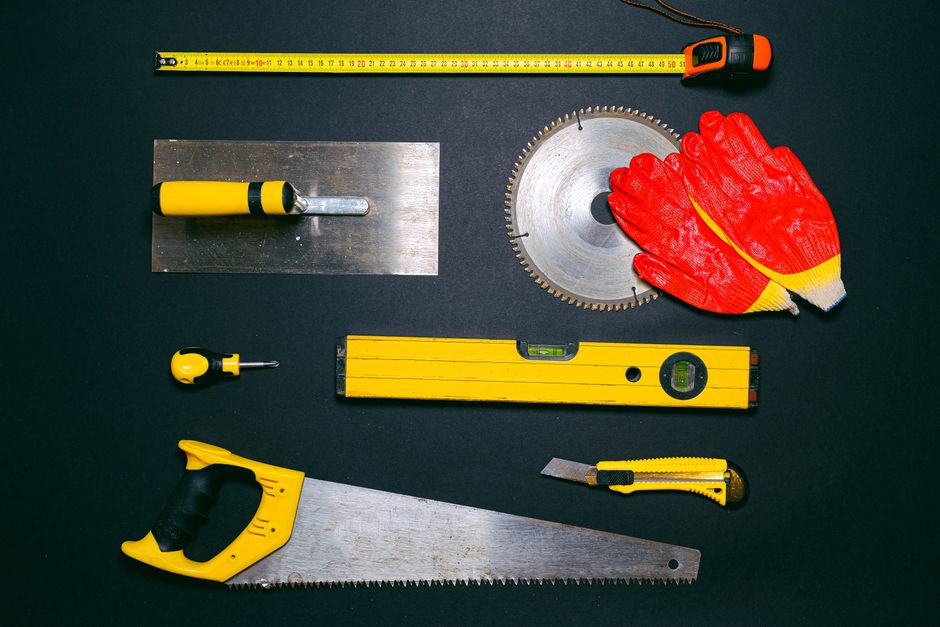 A set of construction hand tools arranged in a flat lay on a dark background. Ideal for DIY projects.