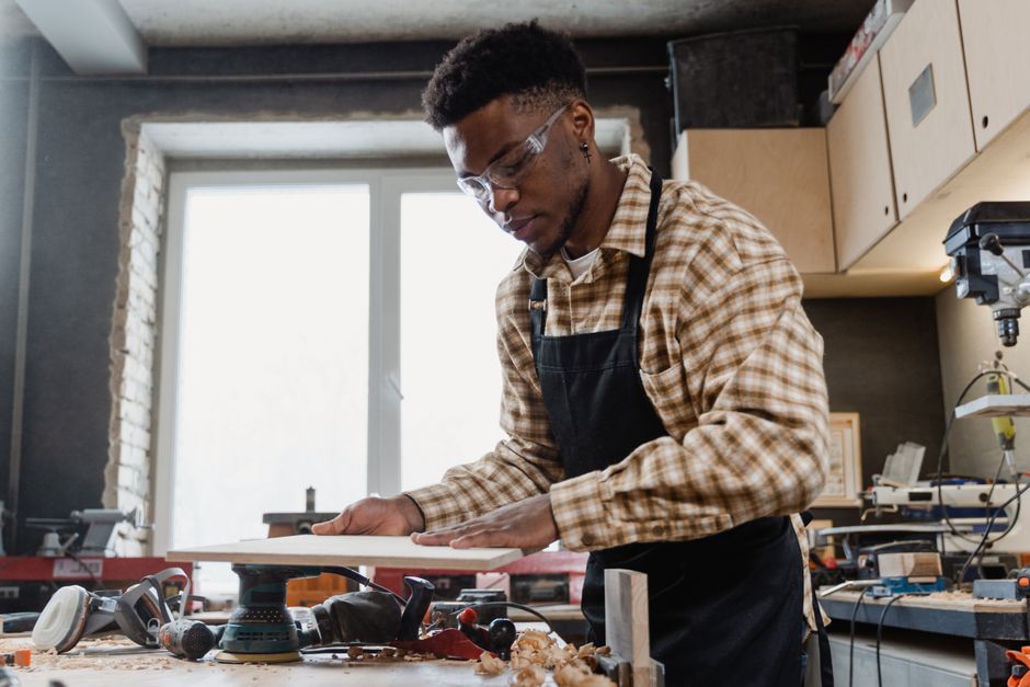 A skilled craftsman working with hand tools in a well-equipped workshop.