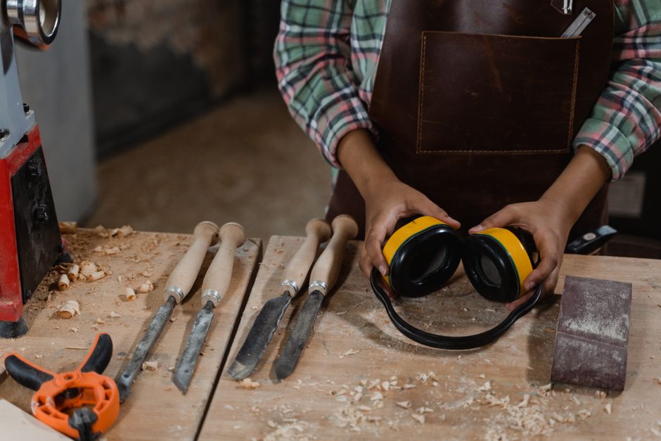 A woodworker prepares tools and equipment in a dusty workshop, demonstrating craftsmanship.