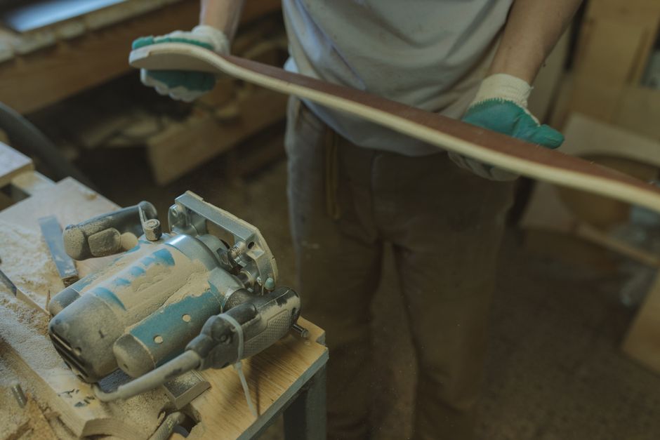 An artisan skillfully shaping wood with power tools in a workshop setting.