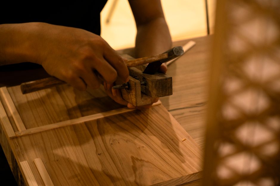 Artisan carefully crafting wood with traditional hand tools, showcasing skill and precision.