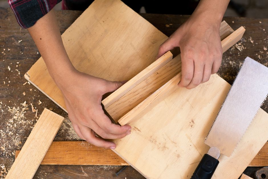 Close-up of hands crafting wood with tools, perfect for DIY carpentry and craft projects.