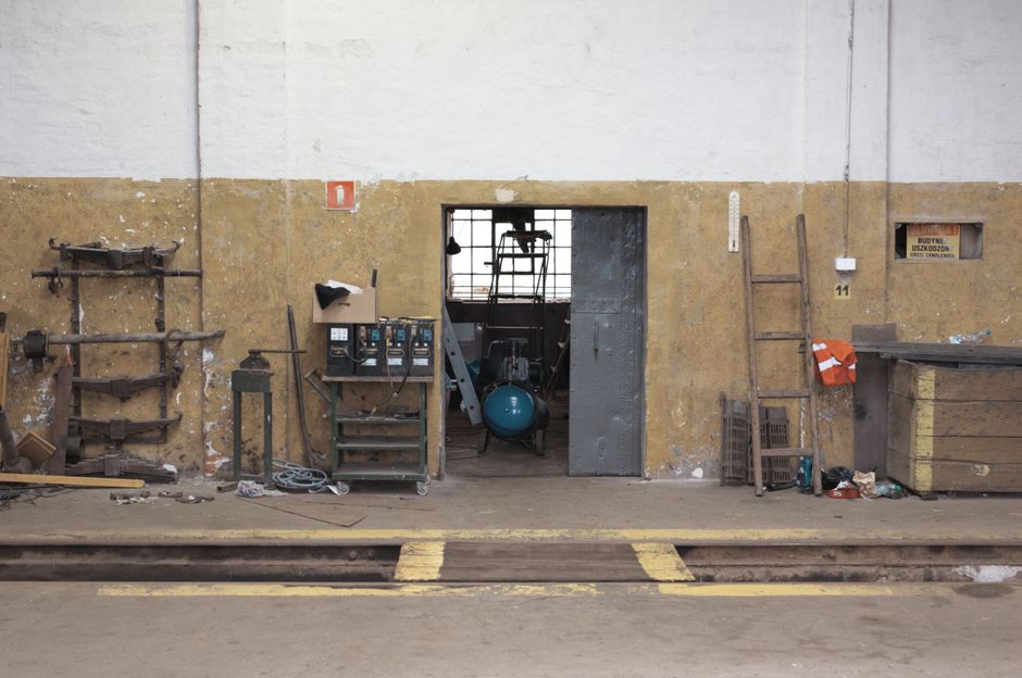 Entrance to a vintage workshop in Łódź, showcasing tools and equipment in an industrial setting.