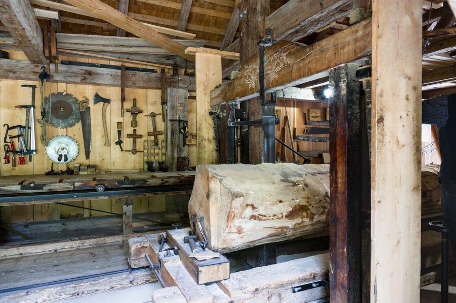 Explore the rustic interior of a traditional Swiss sawmill featuring woodworking tools.
