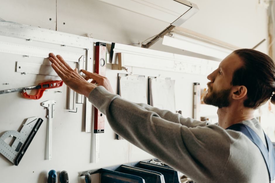 Focused woodworker arranging tools on a workbench, highlighting precision and craftsmanship.
