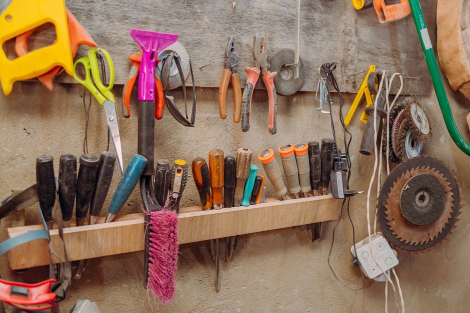 Organized hand tools on wall in a workshop. Essential carpentry equipment neatly displayed.