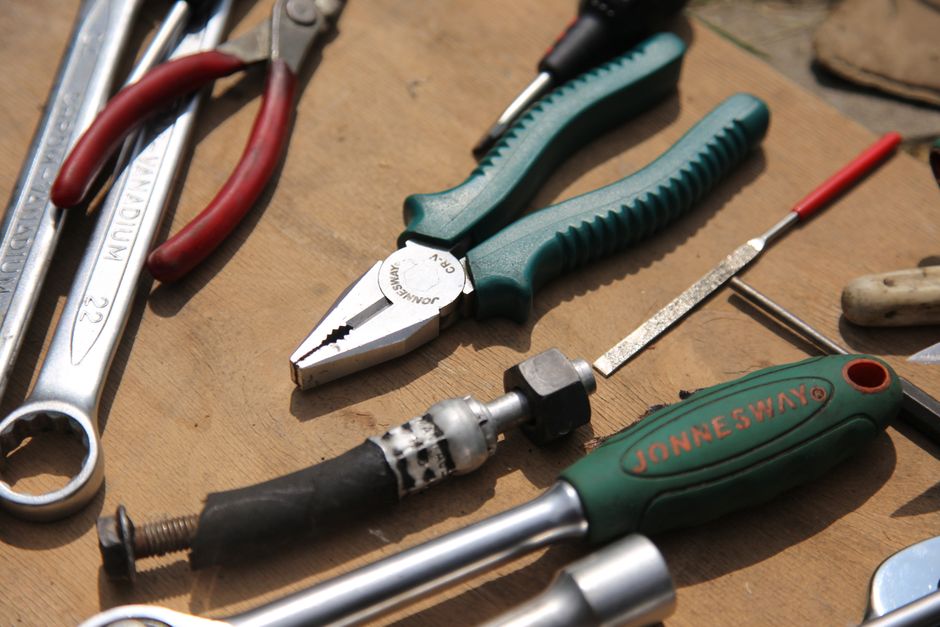 Close-up of assorted hand tools on a wooden surface, perfect for DIY projects.