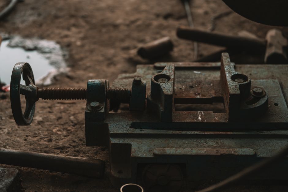 Close-up of rusty industrial tools in a workshop setting, emphasizing craftsmanship.