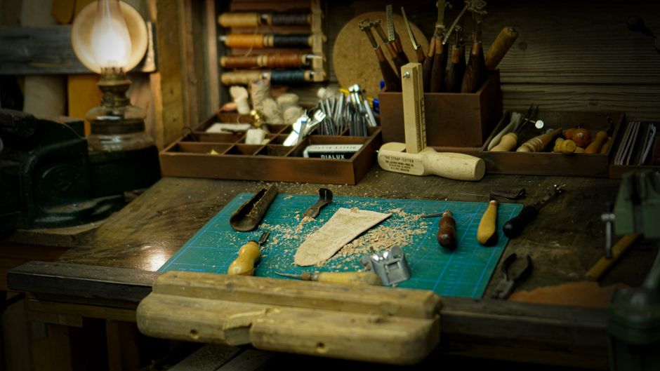 Explore a vintage workshop table setup with various tools and wooden accessories, perfect for crafting.