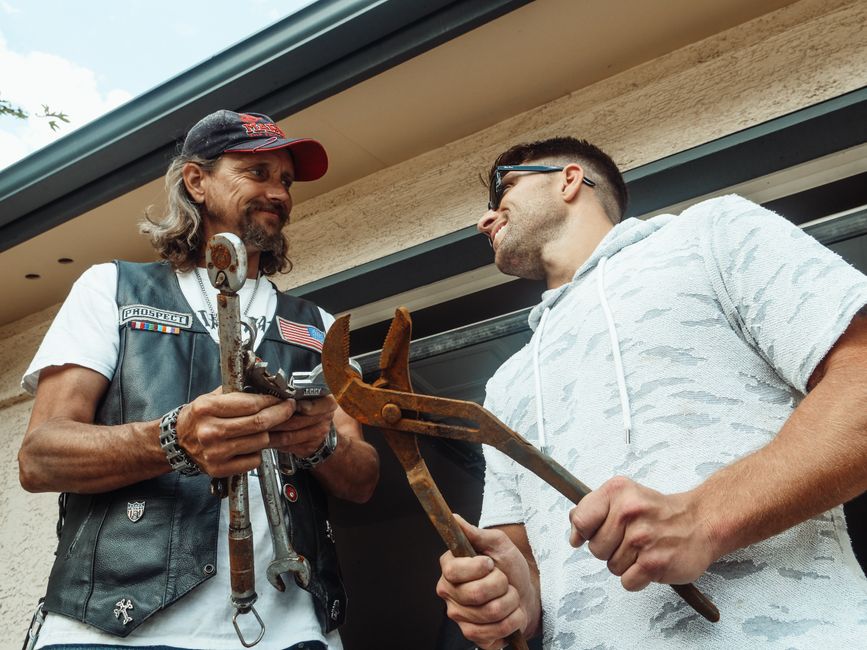 Father and son bond over handyman activities with tools, sharing smiles and skills.